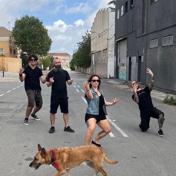 Cuatro capullos y un perro en un callejón.